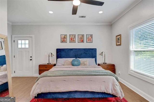 bedroom featuring crown molding, light hardwood / wood-style flooring, multiple windows, and ceiling fan