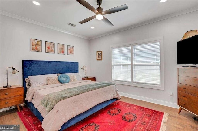 bedroom featuring hardwood / wood-style flooring, ceiling fan, and ornamental molding