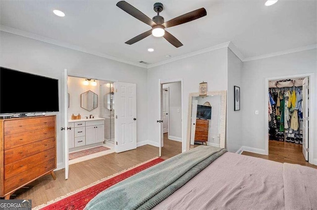 bedroom with ornamental molding, ensuite bathroom, ceiling fan, light hardwood / wood-style flooring, and a closet