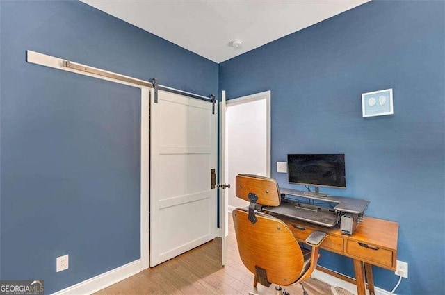 office space with light wood-type flooring and a barn door