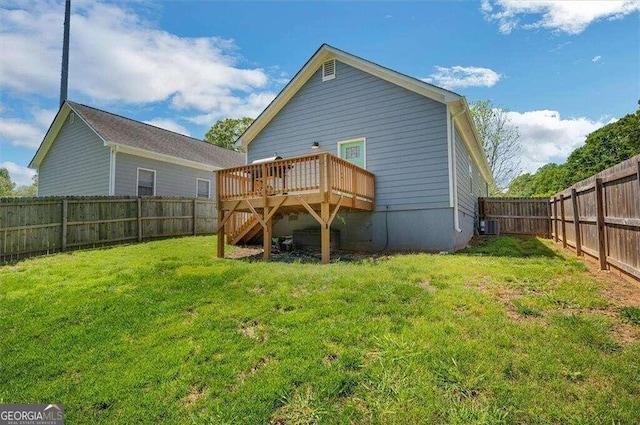 rear view of property featuring a wooden deck and a yard