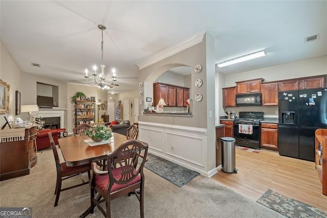 dining room featuring an inviting chandelier, light hardwood / wood-style floors, and crown molding