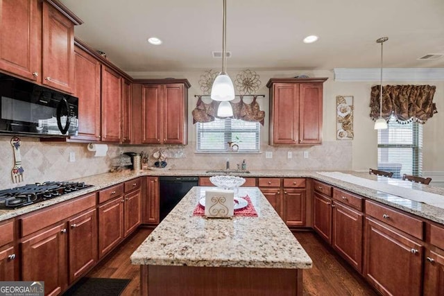 kitchen with a center island, a sink, hanging light fixtures, and black appliances