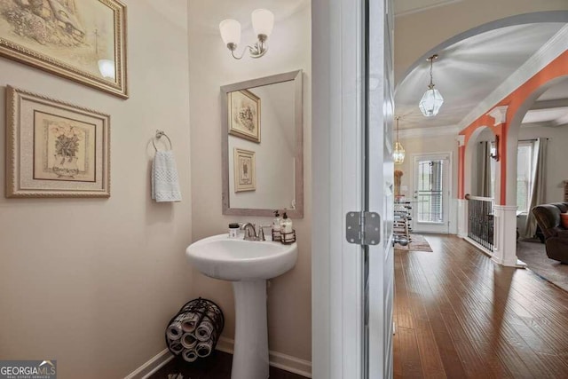 bathroom featuring ornamental molding, wood finished floors, and baseboards