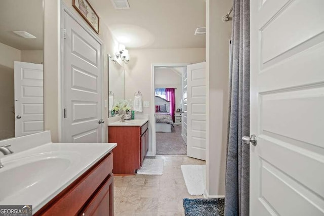 ensuite bathroom with a sink, visible vents, two vanities, and connected bathroom