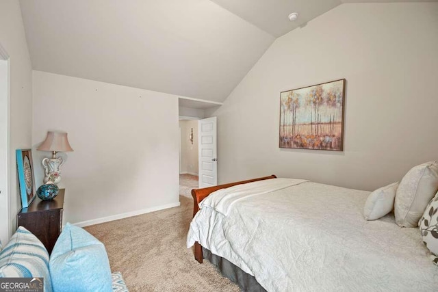 carpeted bedroom featuring baseboards and vaulted ceiling