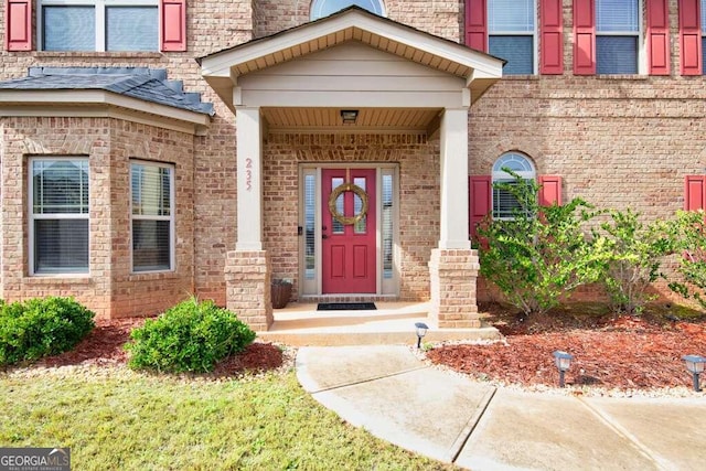 doorway to property featuring brick siding