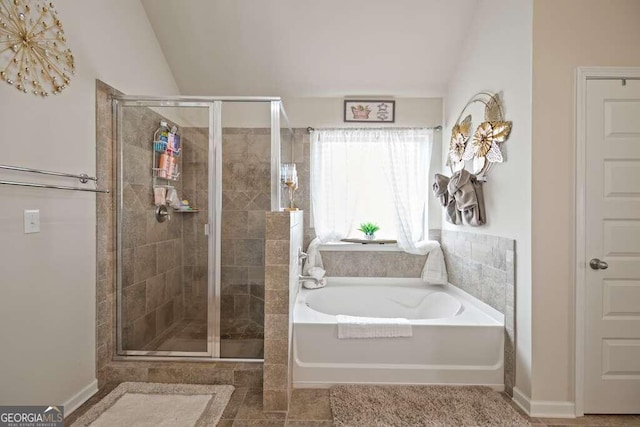 full bath with vaulted ceiling, a shower stall, and a bath