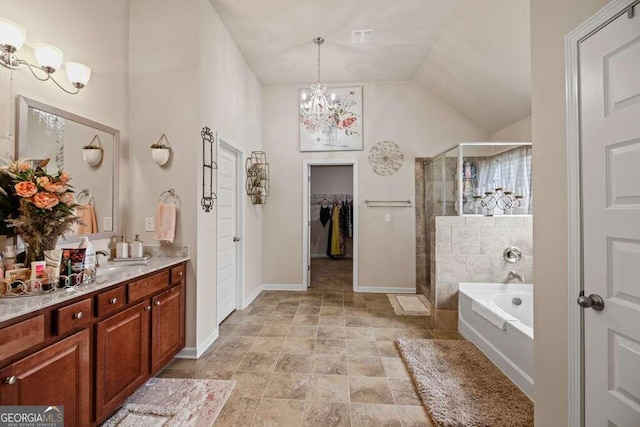 bathroom featuring a chandelier, shower with separate bathtub, vanity, and vaulted ceiling