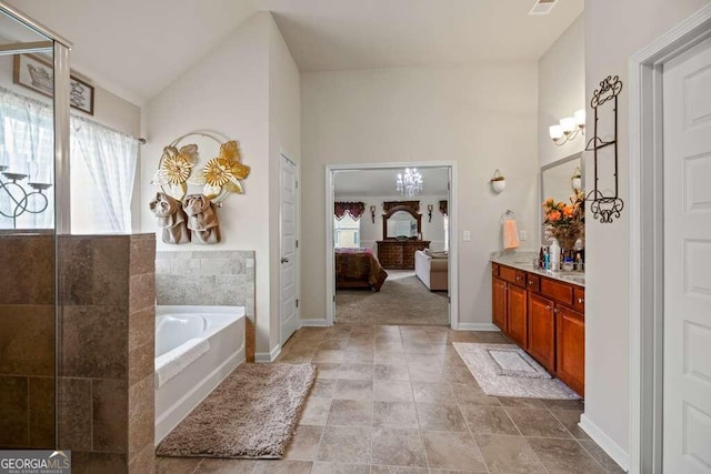 ensuite bathroom with an inviting chandelier, vaulted ceiling, vanity, ensuite bath, and a bath