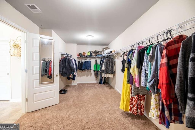 walk in closet featuring visible vents and light colored carpet