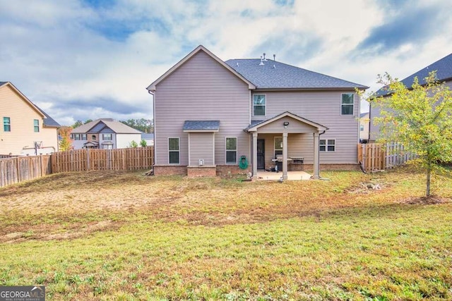 rear view of house featuring a patio area, a fenced backyard, and a yard