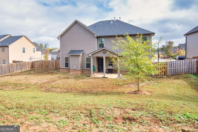 rear view of house with a patio area, a fenced backyard, and a yard