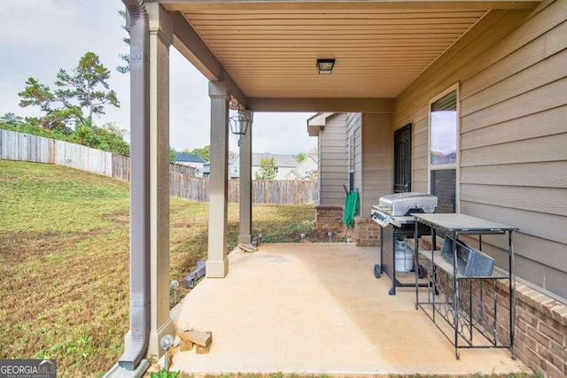 view of patio featuring a fenced backyard, grilling area, and exterior bar