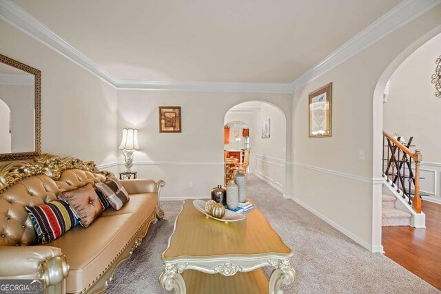 living room with ornamental molding, arched walkways, carpet floors, and stairs