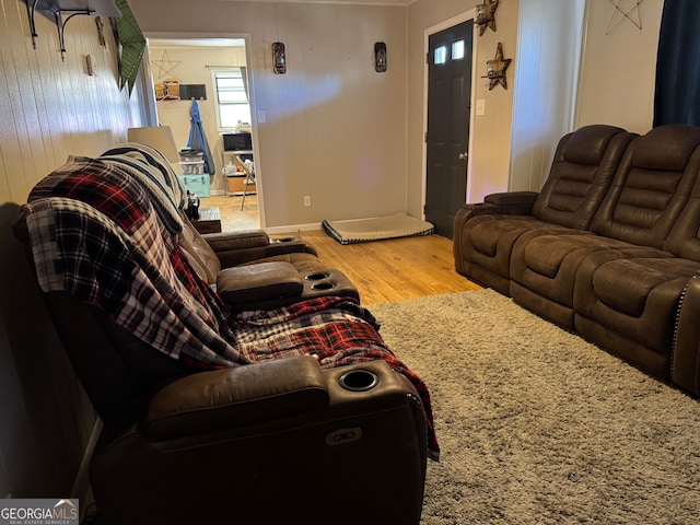 living room featuring wood-type flooring and wooden walls