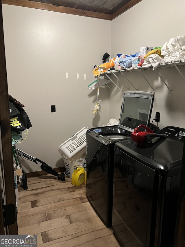 laundry room with washer and clothes dryer and light hardwood / wood-style flooring