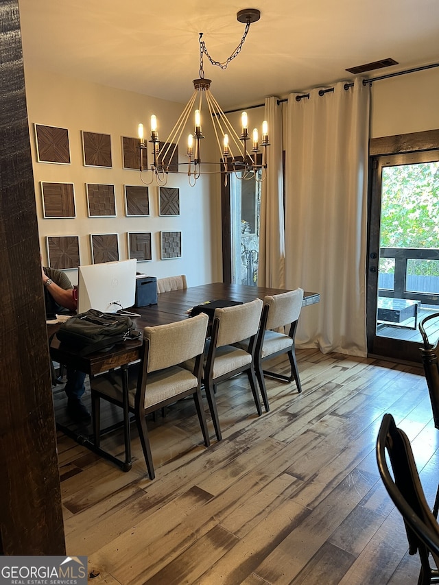 dining space featuring a chandelier and wood-type flooring