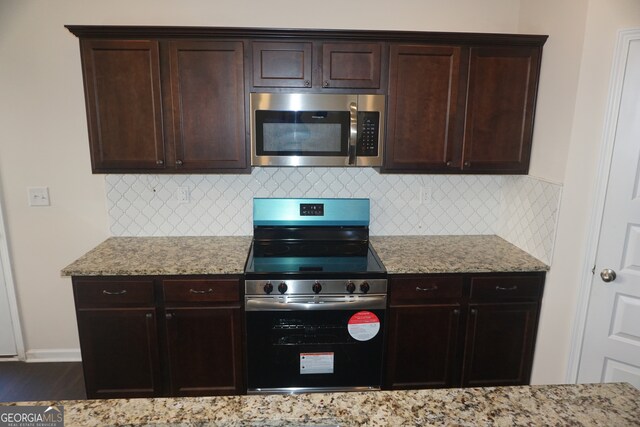 kitchen featuring decorative backsplash, light stone counters, and appliances with stainless steel finishes