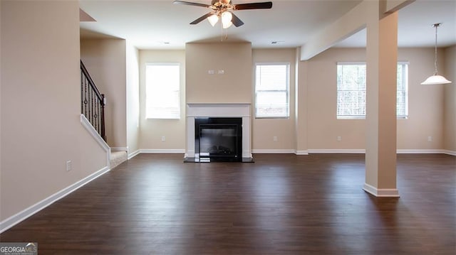 unfurnished living room with ceiling fan and dark hardwood / wood-style floors