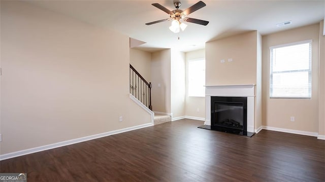 unfurnished living room with dark wood-type flooring and ceiling fan