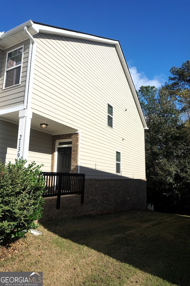 view of side of home with a yard