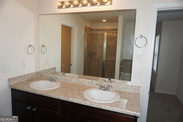 bathroom with a shower with door and vanity