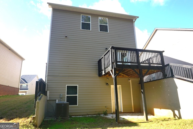 back of house featuring central AC unit, a lawn, and a deck