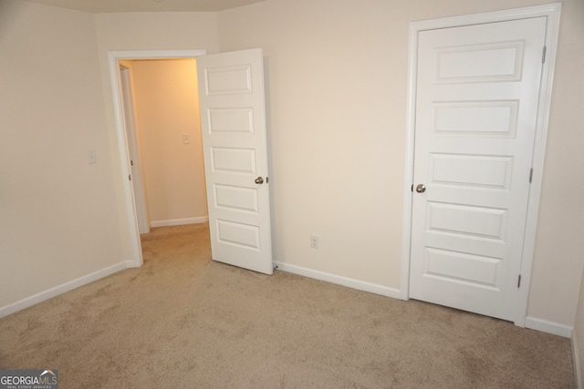 unfurnished bedroom featuring light carpet