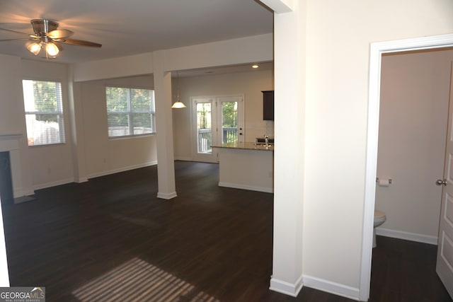 unfurnished living room featuring ceiling fan and dark hardwood / wood-style floors