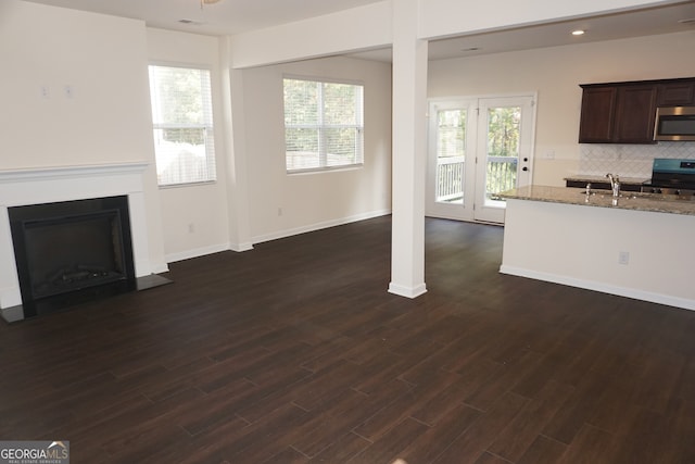 unfurnished living room featuring dark wood-type flooring and sink