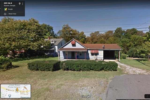 view of front facade with a porch, a carport, and a front yard