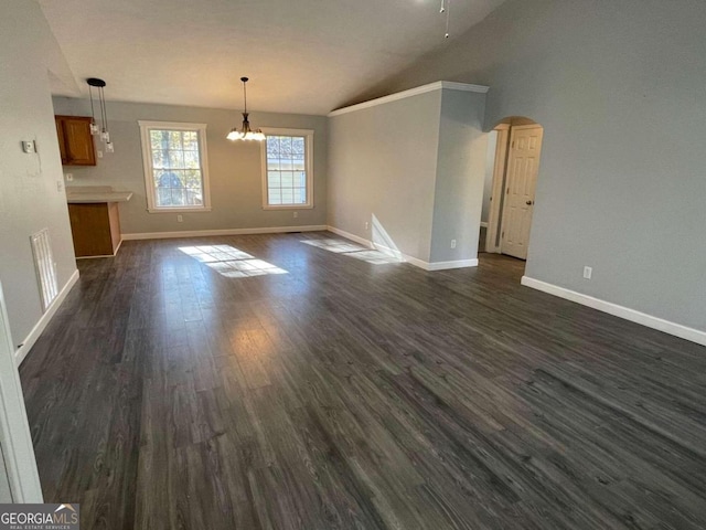 unfurnished living room featuring vaulted ceiling, dark hardwood / wood-style floors, and ceiling fan with notable chandelier