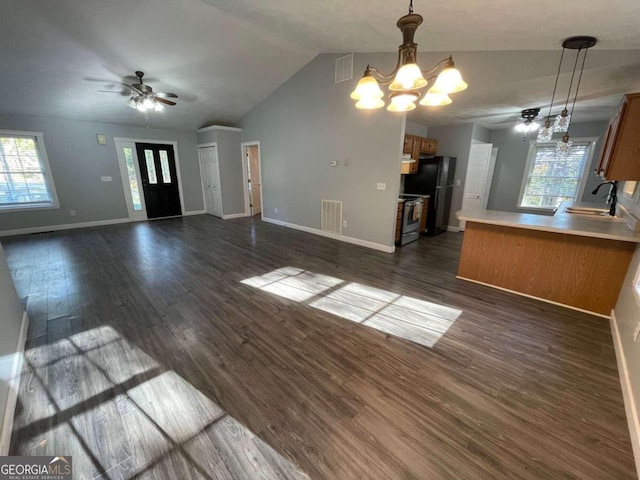 interior space featuring sink, dark hardwood / wood-style floors, black refrigerator, pendant lighting, and stainless steel range