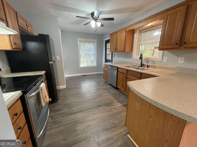 kitchen featuring kitchen peninsula, appliances with stainless steel finishes, sink, and dark hardwood / wood-style flooring