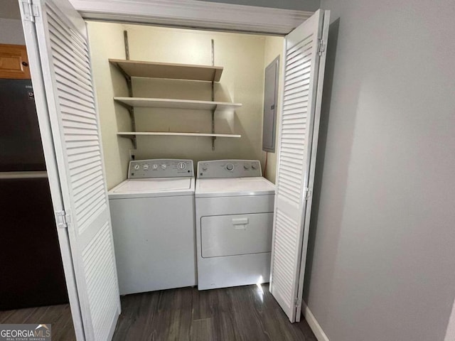 washroom featuring washing machine and dryer, electric panel, and dark hardwood / wood-style floors