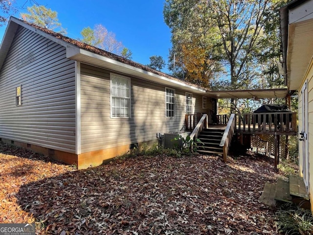 view of side of home featuring central AC and a wooden deck