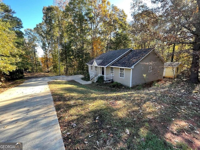 view of side of home with a lawn and a storage shed