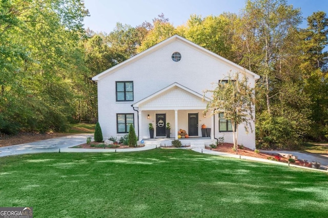 view of front facade with a front yard and covered porch