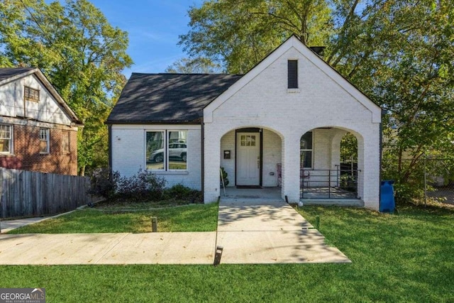 english style home with a porch and a front yard