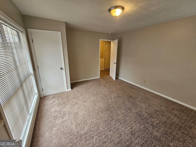 unfurnished bedroom with a closet, carpet, and a textured ceiling