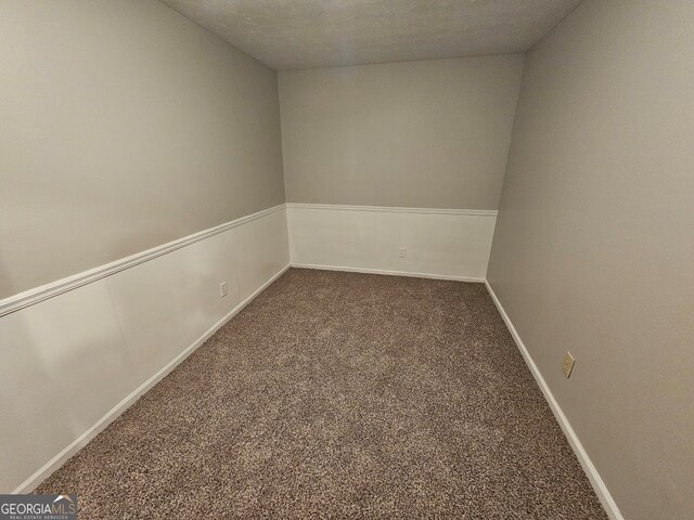 empty room with carpet and a textured ceiling