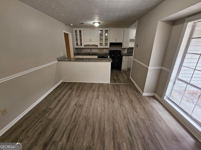 kitchen with white cabinets, a wealth of natural light, dark hardwood / wood-style floors, and kitchen peninsula