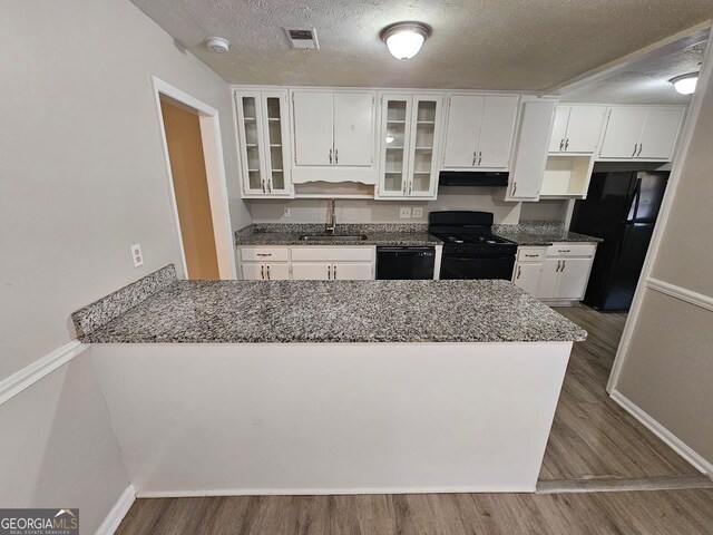 kitchen featuring black appliances, dark wood-type flooring, sink, and white cabinets