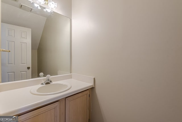 bathroom with vanity and vaulted ceiling