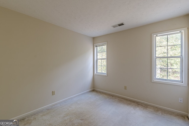 carpeted spare room featuring a textured ceiling