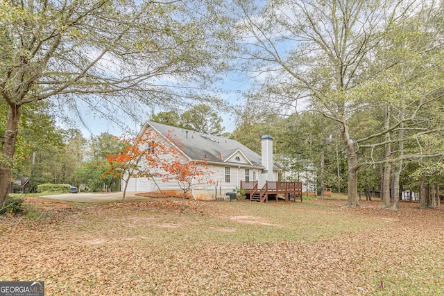 view of yard with a garage and a wooden deck