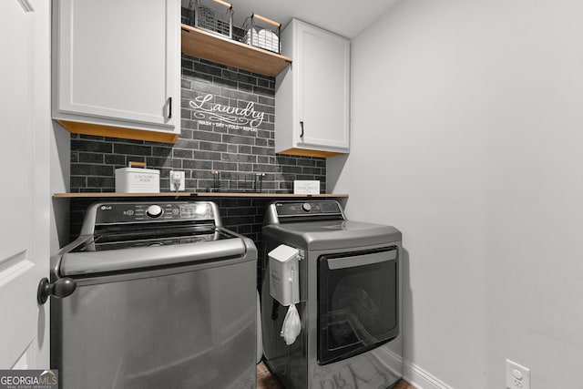 clothes washing area with cabinets and independent washer and dryer