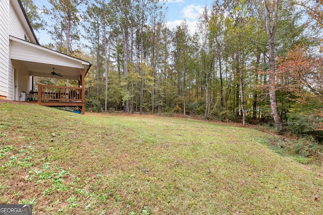 view of yard featuring a wooden deck and ceiling fan