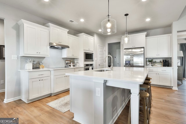 kitchen featuring white cabinetry, pendant lighting, sink, and stainless steel appliances